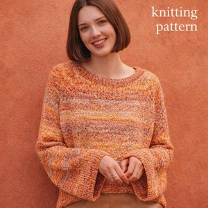May include: A knitted sweater in shades of orange, yellow, and pink. The sweater has a round neckline and long sleeves with flared cuffs. The text "knitting pattern" is in the upper right corner.