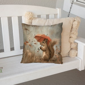 a pillow with a picture of a squirrel holding an umbrella