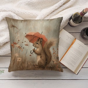 a pillow with a squirrel holding an umbrella