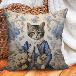 May include: A decorative cushion featuring a vintage illustration of a cat wearing a blue and gold jacket and holding a bouquet of white roses. The background is a floral pattern with blue roses and leaves.