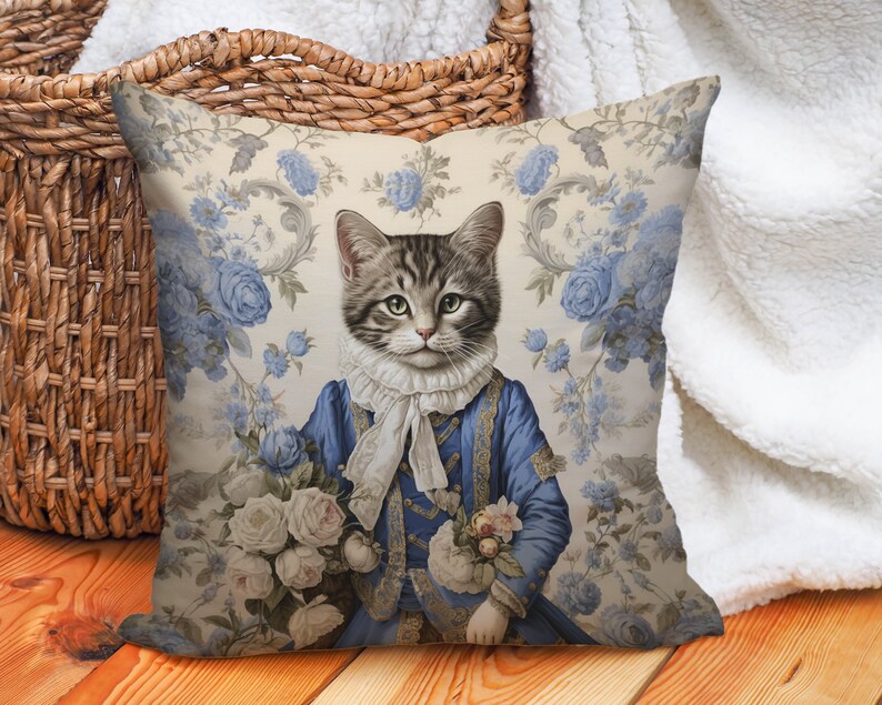 May include: A decorative cushion featuring a vintage illustration of a cat wearing a blue and gold jacket and holding a bouquet of white roses. The background is a floral pattern with blue roses and leaves.