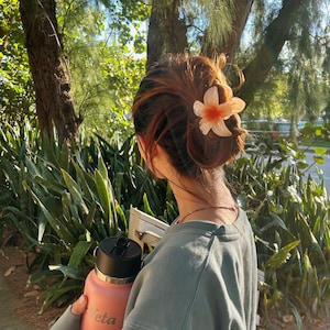彼女の髪に花を添えたピーチ | オレンジフラワークロークリップ ビーチヘアアクセサリー パステルカラーのガーリーなヘアクリップ ロングヘア用 クリップ フラワーヘアクリップ