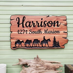 May include: A wooden sign with the name "Harrison" and the address "1271 South Marion" carved into it. The sign also features a silhouette of a group of horses and a rider.