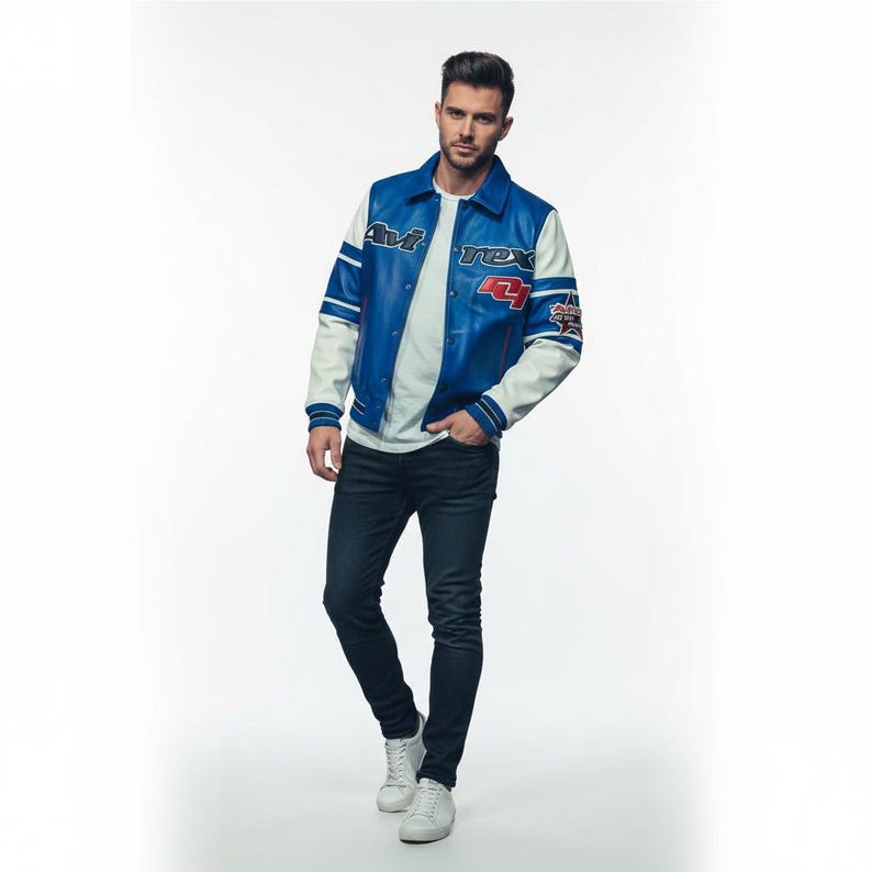May include: A blue and white leather jacket with the text "Avi Rex 4" on the front. The jacket has white sleeves and blue accents. The person is wearing a white t-shirt, dark blue jeans, and white sneakers.