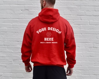 May include: Red hooded sweatshirt with white text that reads "YOUR DESIGN HERE MILK & HONEY HOOKS" on the back.