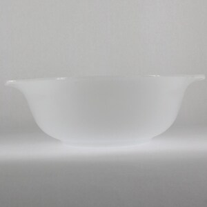 May include: A white, opaque, round mixing bowl with a scalloped rim.