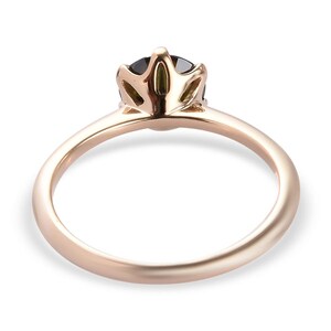 May include: A rose gold ring with a black gemstone set in a crown-shaped setting.