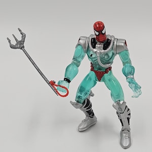 May include: A Spider-Man action figure with a red and black mask, a transparent teal body, and silver armor. The figure is holding a silver trident with a red handle. The figure is in a crouching pose.