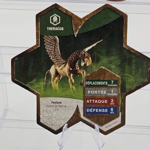 Może przedstawiać: Karta do gry z ilustracją skrzydlatego konia, o nazwie "THERACUS". Karta zawiera statystyki gry i tekst "Feylund Vision de Raknar 3/5". Tło jest zielono-brązowe, z informacją o prawach autorskich Hasbro.