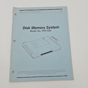 May include: A light blue manual titled "Disk Memory System" for the Texas Instruments Home Computer. The model number is PHP1240. The manual includes a diagram of a disk drive controller card and text describing its features.