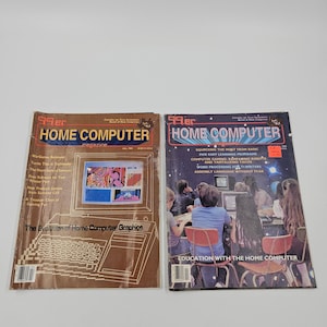 May include: Two vintage "99er Home Computer" magazines. One has a brown cover with the text "The Evolution of Home Computer Graphics." The other has a dark cover with the text "Education with the Home Computer."