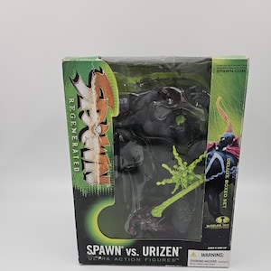 Puede incluir: Un set de figuras de acción deluxe Spawn vs. Urizen de McFarlane Toys. El empaque presenta gráficos en verde y negro con el texto Spawn Regenerated y Spawn vs. Urizen. Una figura oscura y texturizada es visible a través de la ventana.