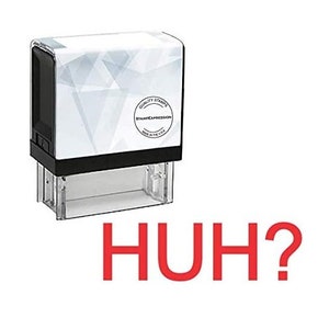 May include: A white self-inking stamp with a black frame and a clear plastic base. The stamp has a geometric pattern and a round label that says "Quality Stamps StampExpression Made in the USA". The text "HUH?" is written in red below the stamp.