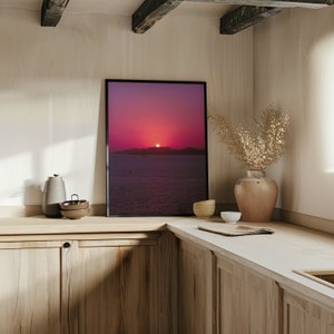Warm sunset and ocean poster in a wooden kitchen with sunlight going through the window