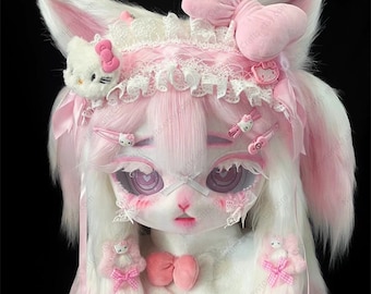 May include: A pink and white furry doll with cat ears, a pink bow, and a Hello Kitty charm. The doll has pink and white hair, pink eyes, and a pink bow around its neck.