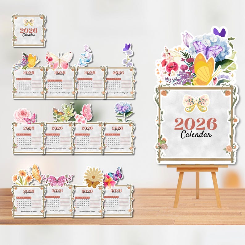 Op de afbeelding: Een verzameling 2026 kalenders met bloemen- en vlindermotieven. De kalenders worden gepresenteerd in een decoratieve opstelling, met verschillende formaten en stijlen, waaronder een grote ezelkalender. Het kleurenpalet omvat zachte pasteltinten en natuurlijke tinten.
