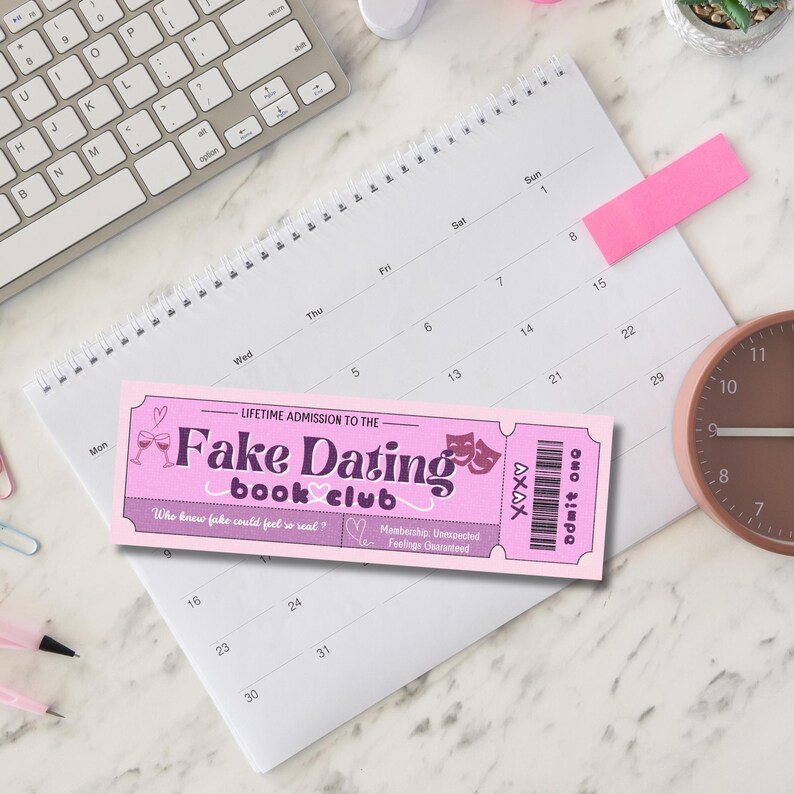 K&ouml;nnte beinhalten: Ein pinkfarbenes und violettes Ticket mit dem Text "Fake Dating Book Club" und dem Slogan "Who knew fake could feel so real?" Das Ticket hat ein pinkfarbenes Herz und eine Zeichnung von zwei Weingl&auml;sern.