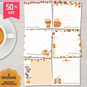 以下が含まれることがあります： さまざまなデザインの、秋をテーマにした6つのメモ帳。各メモ帳には、秋の葉、カボチャ、コーヒーカップのイラストが描かれています。罫線入りのページもあれば、白紙のページもあります。「Gratitude grows happiness」と「Fall into gratitude」の文字が含まれています。