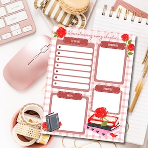 Puede incluir: Un planificador rosa y blanco con el texto "Romanticizing every chapter". El planificador presenta secciones para listas de tareas, recordatorios, notas y prioridades, decoradas con rosas y libros. Un rat&oacute;n y un teclado rosas est&aacute;n en el fondo.