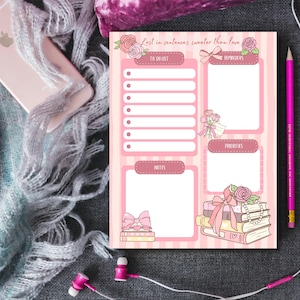 Puede incluir: Bloc de notas a rayas rosas y blancas con secciones para listas de tareas, recordatorios, notas y prioridades. El bloc de notas presenta ilustraciones florales y lazos, con el texto "Lost in sentences sweeter than love."