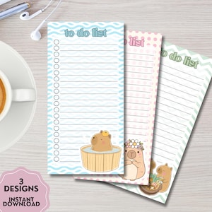 May include: A white ceramic mug with a black handle and the text "But First, Coffee" in a bold, black font. The mug is set against a blurred background, suggesting a cozy setting.