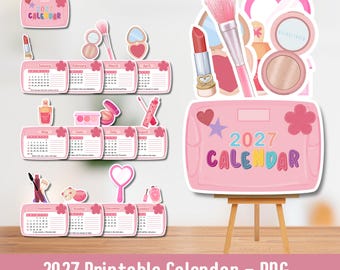 May include: A 2027 calendar set featuring twelve monthly cards decorated with pink makeup illustrations including lipstick, brushes, and compact mirrors. The calendar cards are arranged in rows, and a large pink sign displays the text 2027 CALENDAR.