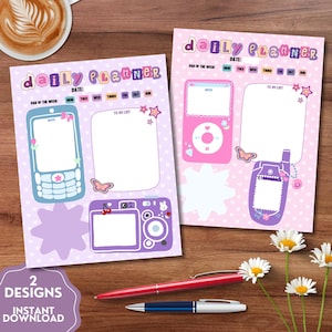 May include: Two daily planner sheets with a light purple heart background. Each sheet features the text daily planner, a date line, and days of the week. Illustrations include a blue mobile phone, a pink music player, a purple camera, and to-do lists.