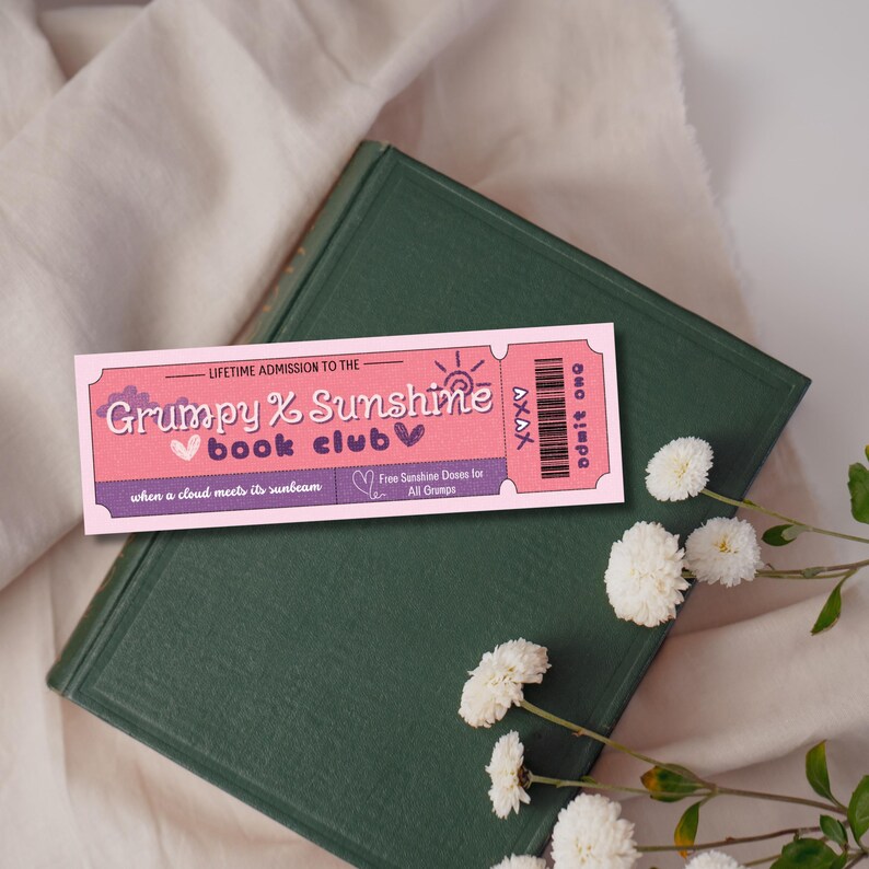K&ouml;nnte beinhalten: Rosa-lilafarbenes Lesezeichen mit dem Text "LIFETIME ADMISSION TO THE Grumpy & Sunshine book club when a cloud meets its sunbeam Free Sunshine Doses for All Grumps" und einer Sonnendarstellung.