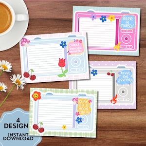 May include: Four digital download designs featuring camera-shaped notepads with lined pages. Each notepad has a unique design with floral and fruit accents, and inspirational phrases like "Believe in Yourself" and "Trust the Journey". The words "4 DESIGN" and "INSTANT DOWNLOAD" are also visible.
