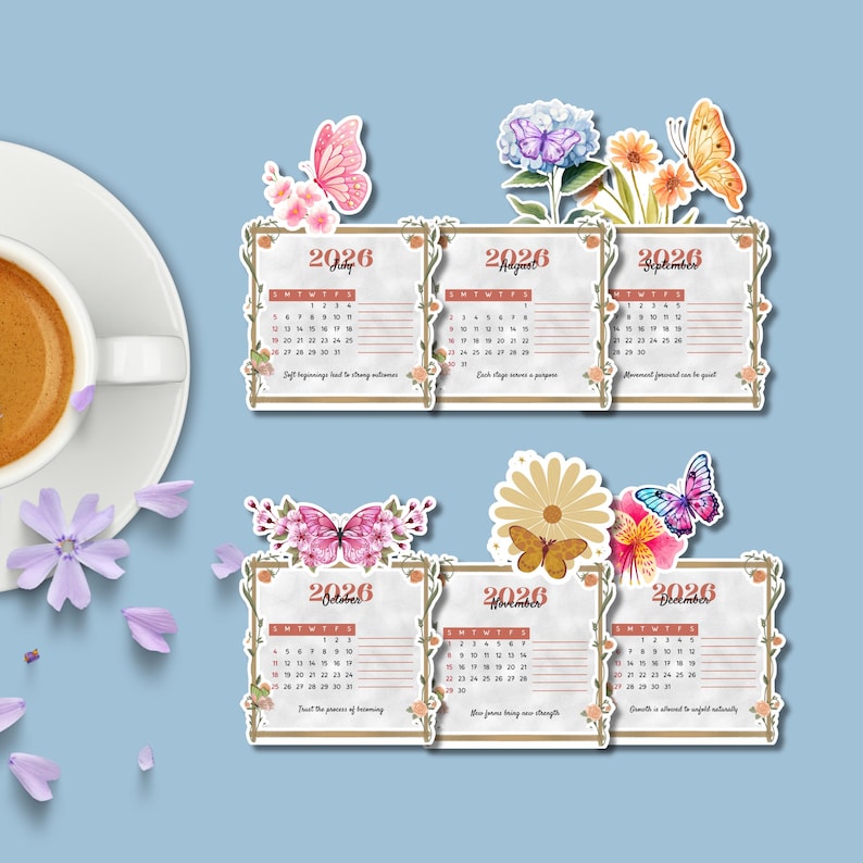 Op de afbeelding: Een set van zes 2026 kalenderstickers, elk met een maand van juli tot en met december. De stickers zijn versierd met bloemen- en vlindermotieven. De kalender staat op een lichte achtergrond met een blauwe achtergrond.