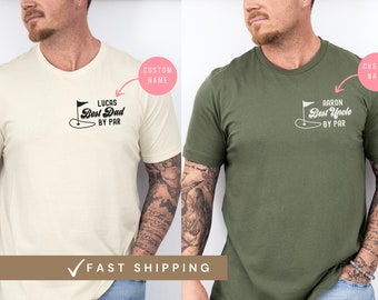 May include: Two t-shirts, one natural and one military green, each with a golf-themed graphic. The natural shirt says "Best Dad by Par" with the name "Lucas". The military green shirt says "Best Uncle by Par" with the name "Aaron".