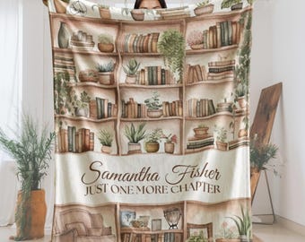 Peut inclure: Une couverture crème avec un motif aquarelle d'une bibliothèque remplie de livres et de plantes en pot. La couverture porte le texte "Samantha Fisher JUST ONE MORE CHAPTER" dans une police décorative.