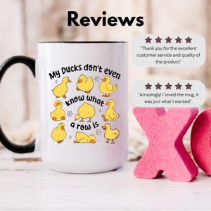 May include: White ceramic mug with a black handle and rim, featuring yellow cartoon ducks and the phrase "My Ducks don't even know what a row is." The mug also includes customer reviews with star ratings.