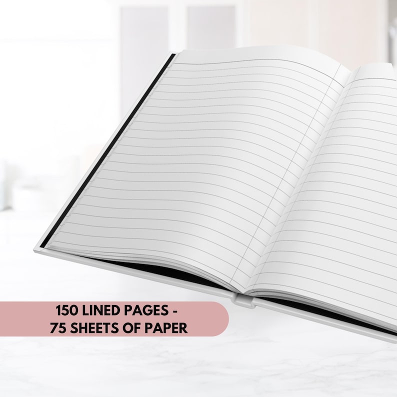 Pode incluir: Um caderno branco com uma lombada preta, aberto para revelar 150 p&aacute;ginas pautadas, ou 75 folhas de papel. O caderno est&aacute; sobre uma superf&iacute;cie branca.