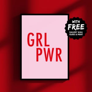 May include: A pink framed print with the text "GRL PWR" in red letters. The print is on a red background with a white "WITH FREE GALLERY WALL GUIDE & PRINT" sticker in the top right corner.