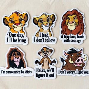 Peut inclure: Un sac fourre-tout beige avec six écussons brodés représentant des personnages et des citations du Roi Lion. Les écussons incluent Simba, Nala, Mufasa, Scar, Timon et Pumbaa. Les citations incluent "Un vrai roi dirige avec courage" et "Ne t'inquiète pas, je t'ai."