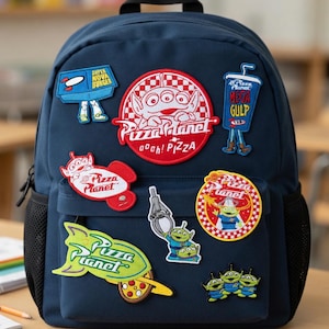 Puede incluir: Mochila azul marino decorada con varios parches de Pizza Planet. Los parches incluyen el logotipo de Pizza Planet, personajes alienígenas y los textos "SUPER NOVA BURGER" y "MEGA GULP". La mochila tiene un bolsillo lateral de malla negro.