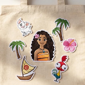 May include: A beige tote bag with several embroidered patches. Patches include a cartoon character with long brown hair, a pig, a rooster, a boat, palm trees, and a pink hibiscus flower. The patches have white borders.
