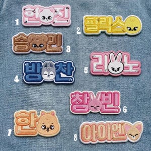 Peut inclure: Écussons brodés de différentes couleurs, avec du texte coréen et des visages d'animaux de dessins animés. Les écussons comprennent des motifs roses, jaunes, marron, bleus et oranges. Chaque écusson a un design et une combinaison de texte uniques.