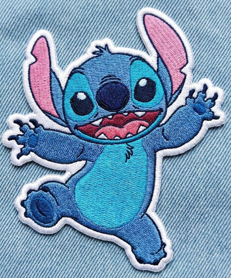May include: Embroidered patch of the character Stitch from Lilo & Stitch. The patch shows Stitch in various shades of blue, with pink ears and a white border. The design depicts Stitch with a wide grin and outstretched arms.