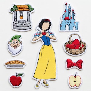May include: Embroidered patches featuring Snow White and related imagery. Includes a well, castle, dwarf, pie, apple, basket of apples, bow, and a half-apple. The central patch depicts Snow White holding an apple, wearing a yellow dress.