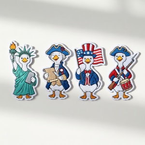 Op de afbeelding: Vier geborduurde patches met cartoonganzen in patriottische kleding. Eén gans houdt een fakkel en een tablet vast, een andere een rol, een derde een vlag en de laatste een geweer en een trommel. Elke patch heeft een witte achtergrond.