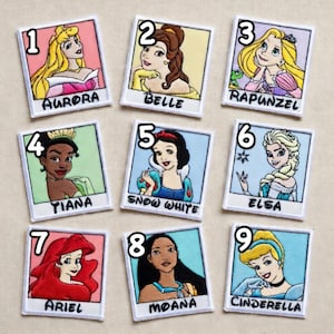 May include: Nine embroidered patches featuring Disney princesses: Aurora, Belle, Rapunzel, Tiana, Snow White, Elsa, Ariel, Moana, and Cinderella. Each patch has a white border and a princess's name below the image.