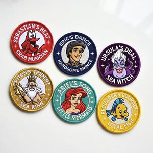 May include: A collection of embroidered patches featuring characters from The Little Mermaid. Each patch is circular with a character illustration and text, including Sebastian, Ariel, Eric, Ursula, Flounder, and King Triton.