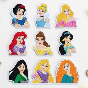 May include: Nine embroidered patches featuring Disney princesses, including Snow White, Cinderella, and Aurora. Each patch showcases a princess with detailed facial features and colorful attire. The patches are outlined in white.