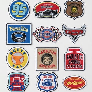 Könnte beinhalten: Eine Sammlung von aufgestickten Aufnähern mit Designs aus dem Film "Cars". Die Aufnäher zeigen Logos und Slogans wie "Lightning McQueen" und "Radiator Springs". Sie sind in verschiedenen Formen und Farben mit detaillierten Stickereien erhältlich.