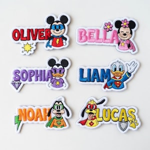 May include: Embroidered patches featuring popular cartoon characters and names like Oliver, Bella, Sophia, Liam, Noah, and Lucas. Each patch has a unique design, with vibrant colors and detailed stitching. The patches are ideal for personalizing clothing or accessories.
