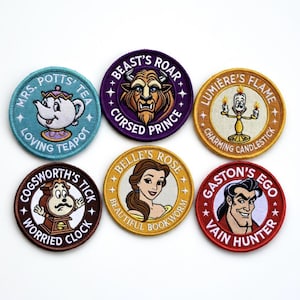 Può includere: Sei toppe ricamate con personaggi di La Bella e la Bestia. I disegni includono Mrs. Potts, Bestia, Lumiere, Chicco, Belle e Gaston. Ogni toppa è circolare con testo e illustrazioni di personaggi.