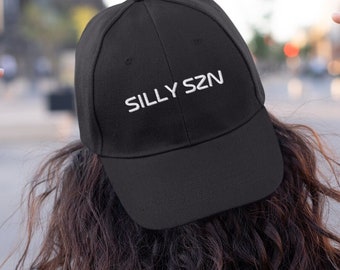 Puede incluir: Una gorra de béisbol negra con bordado blanco que dice "SILLY SZN".