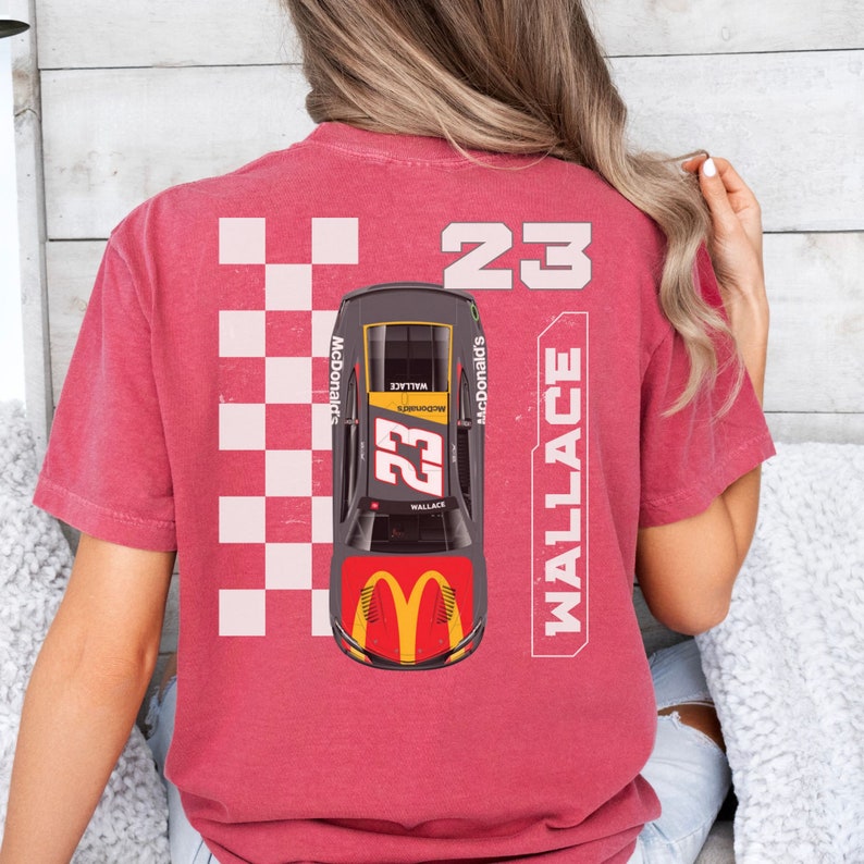 May include: Red t-shirt with a checkered pattern, a race car with the number 23 and the name Wallace, and the words "McDonald's" on the side. The car has a yellow and red McDonald's logo on the hood.